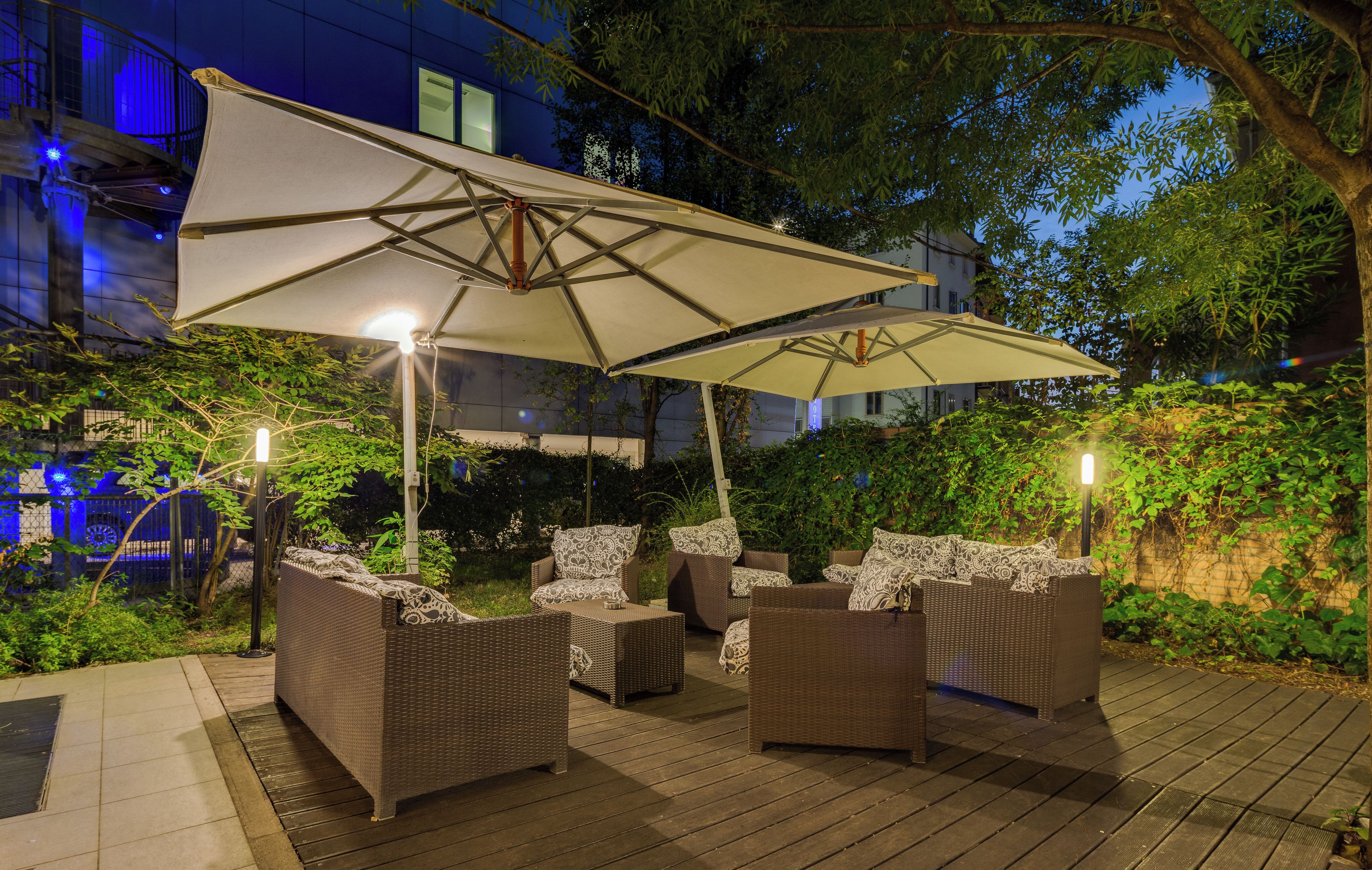 An outdoor seating area with wicker furniture and a large umbrella.