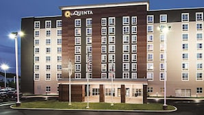A multi-story hotel with a prominent 'La Quinta' sign, featuring a modern architectural design with a mix of brick and glass facades.