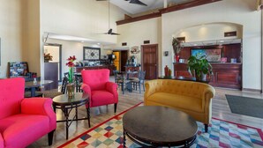 A spacious lobby with a high ceiling, a ceiling fan, and a large dining area with a red and yellow sofa set. - Best Western Benton Inn (Benton)