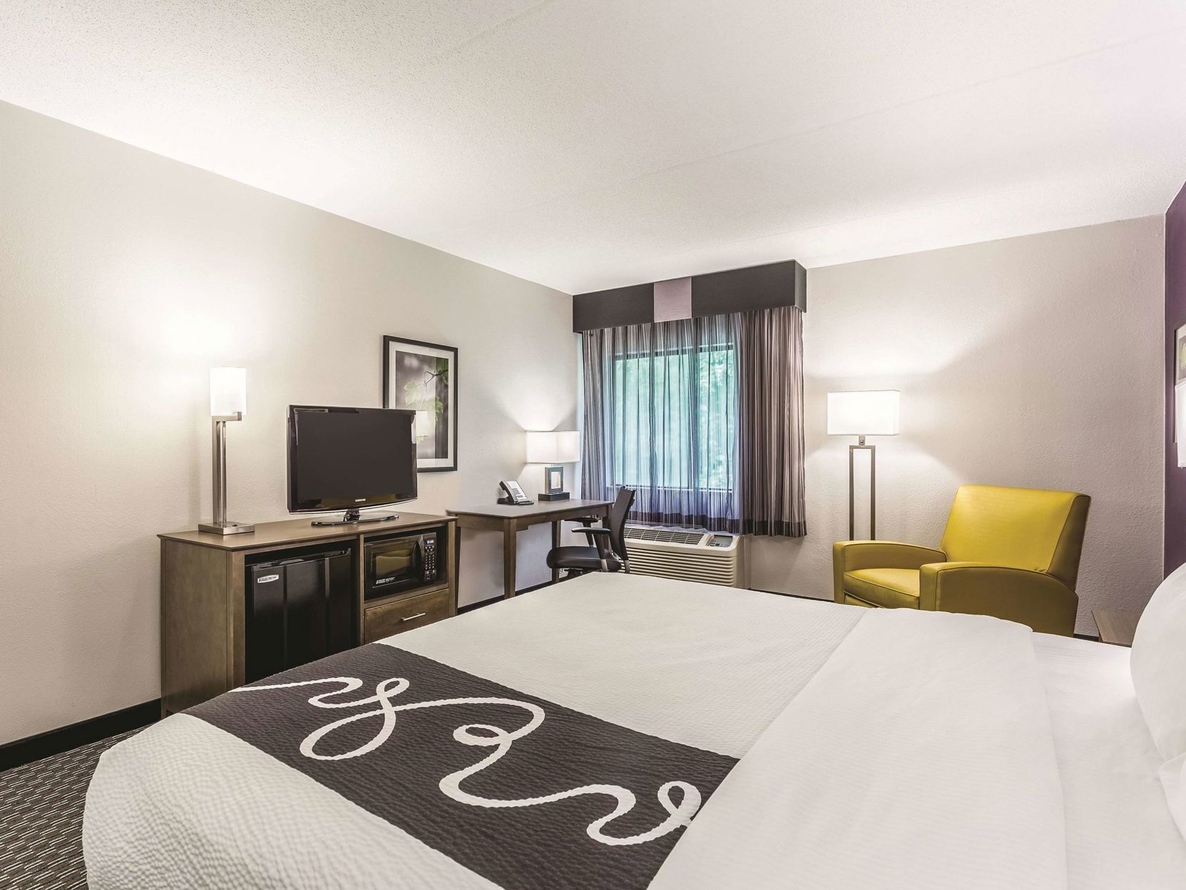 Premium bedding, desk, laptop workspace, blackout drapes