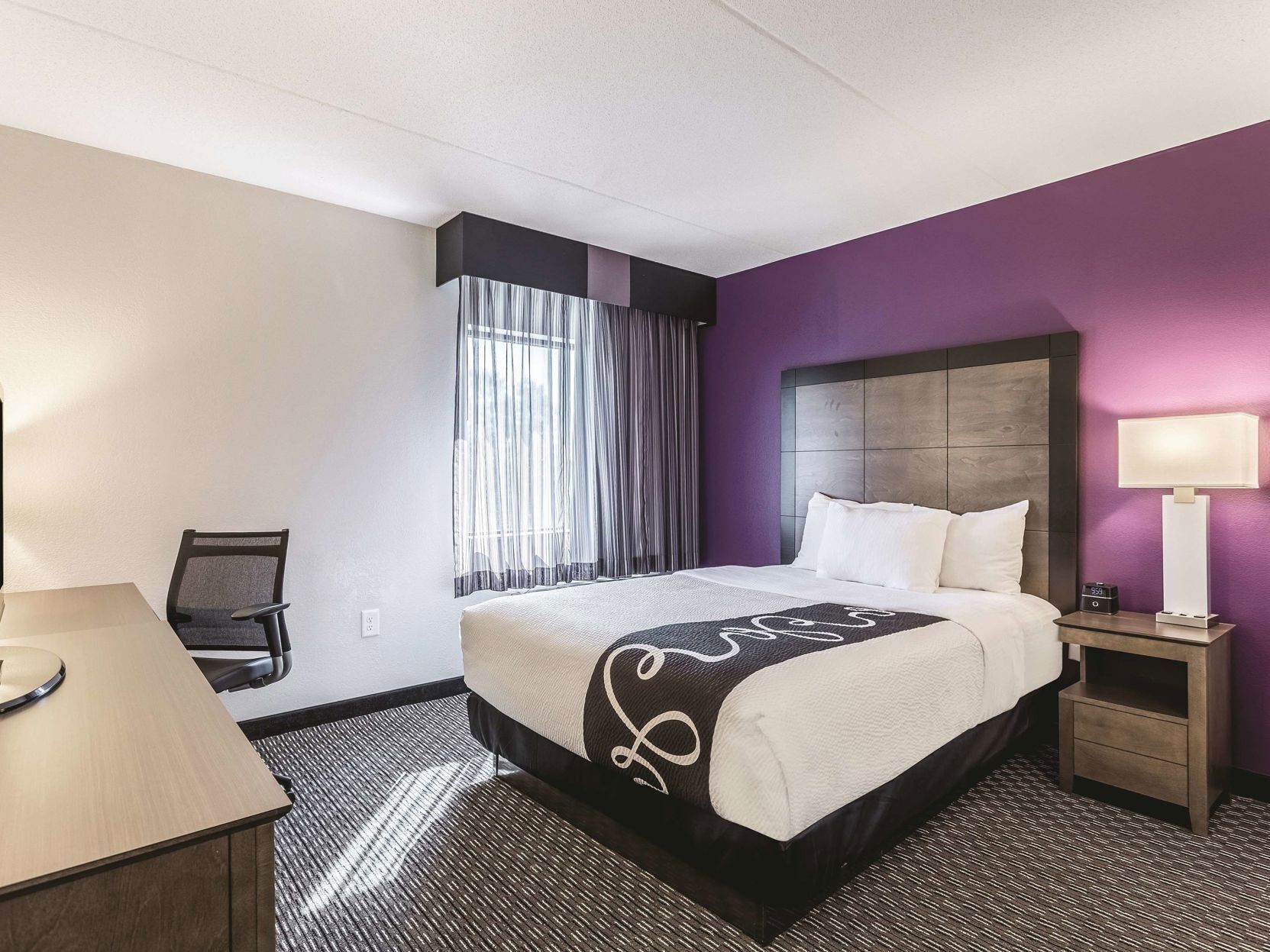 Premium bedding, desk, laptop workspace, blackout drapes