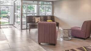 A lobby with a sofa, chairs, and a patterned rug. - La Quinta Inn & Suites by Wyndham Columbia / Fort Meade (Jessup)
