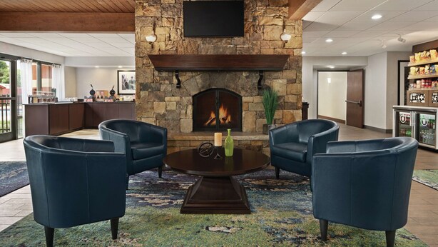 A lobby with a stone fireplace, a flat-screen TV, and a bar area. - Hampton Inn Atlanta Stone Mountain (Stone Mountain)