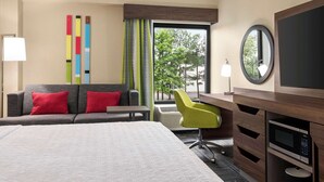 A hotel room with a bed, a desk with a chair, a television, and a window with curtains. - Hampton Inn Atlanta Stone Mountain (Stone Mountain)