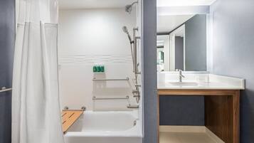 A modern bathroom with a bathtub, shower, and vanity.