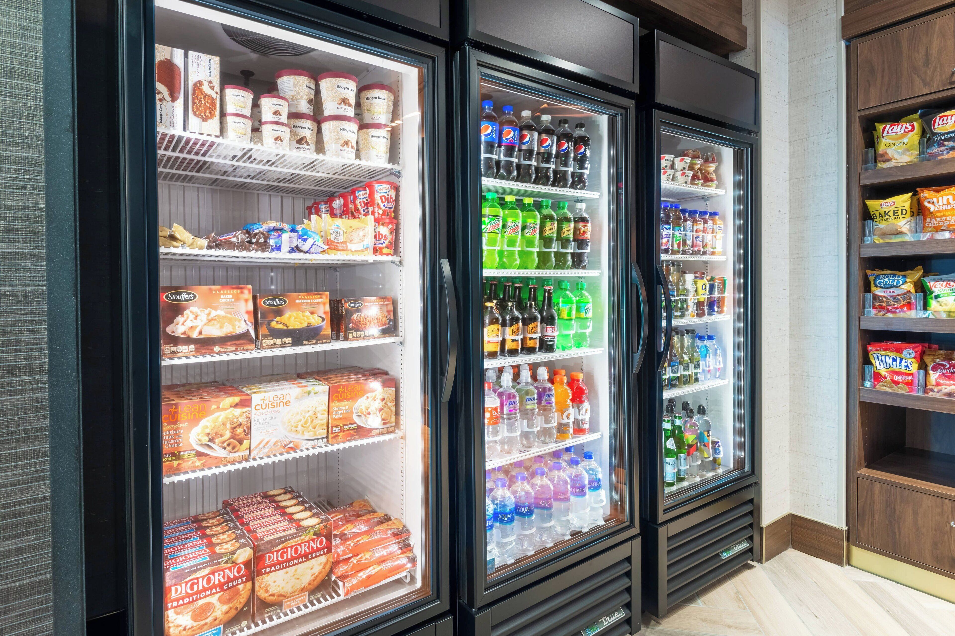 Three refrigerated display cases stocked with various food items and beverages.