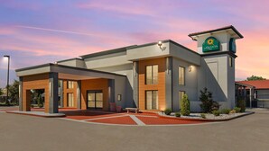 Egy modern hotel, amelyen jól láthatóan ki van írva a „La Quinta Inn” felirat. Lapos tetővel, nagy ablakokkal és egy gondozott kültéri területtel rendelkezik, ahol vörös téglából készült járda és kis növények találhatók.