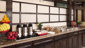 A buffet setup with fruits, beverages, and condiments. - Ramada by Wyndham Newark/Wilmington (Newark)