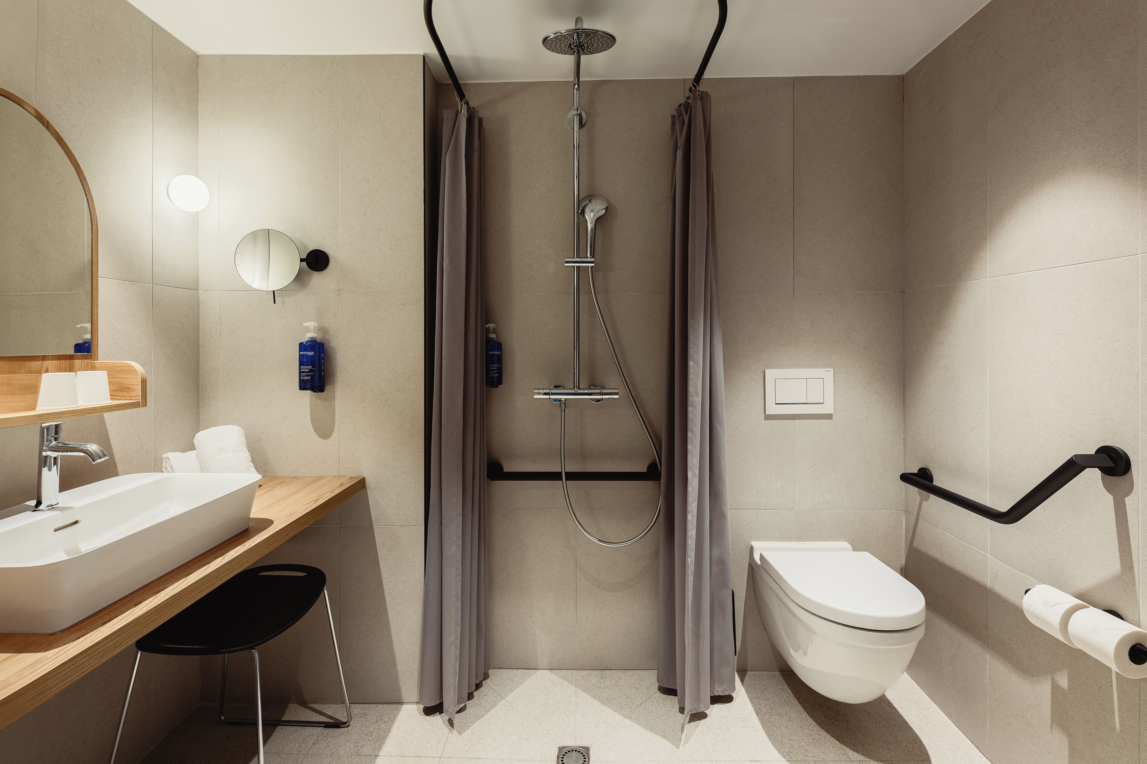 A modern bathroom with a sink, mirror, toilet, and shower.