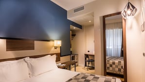 A hotel room with a large bed, a desk, and a chair. There is a mirror on the wall and a window with curtains. - Best Western Hotel Metropoli (Genoa)