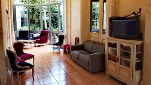 A spacious room with a large window, a television on a cabinet, and several chairs and a sofa. - Best Western Central Hotel (Tours)
