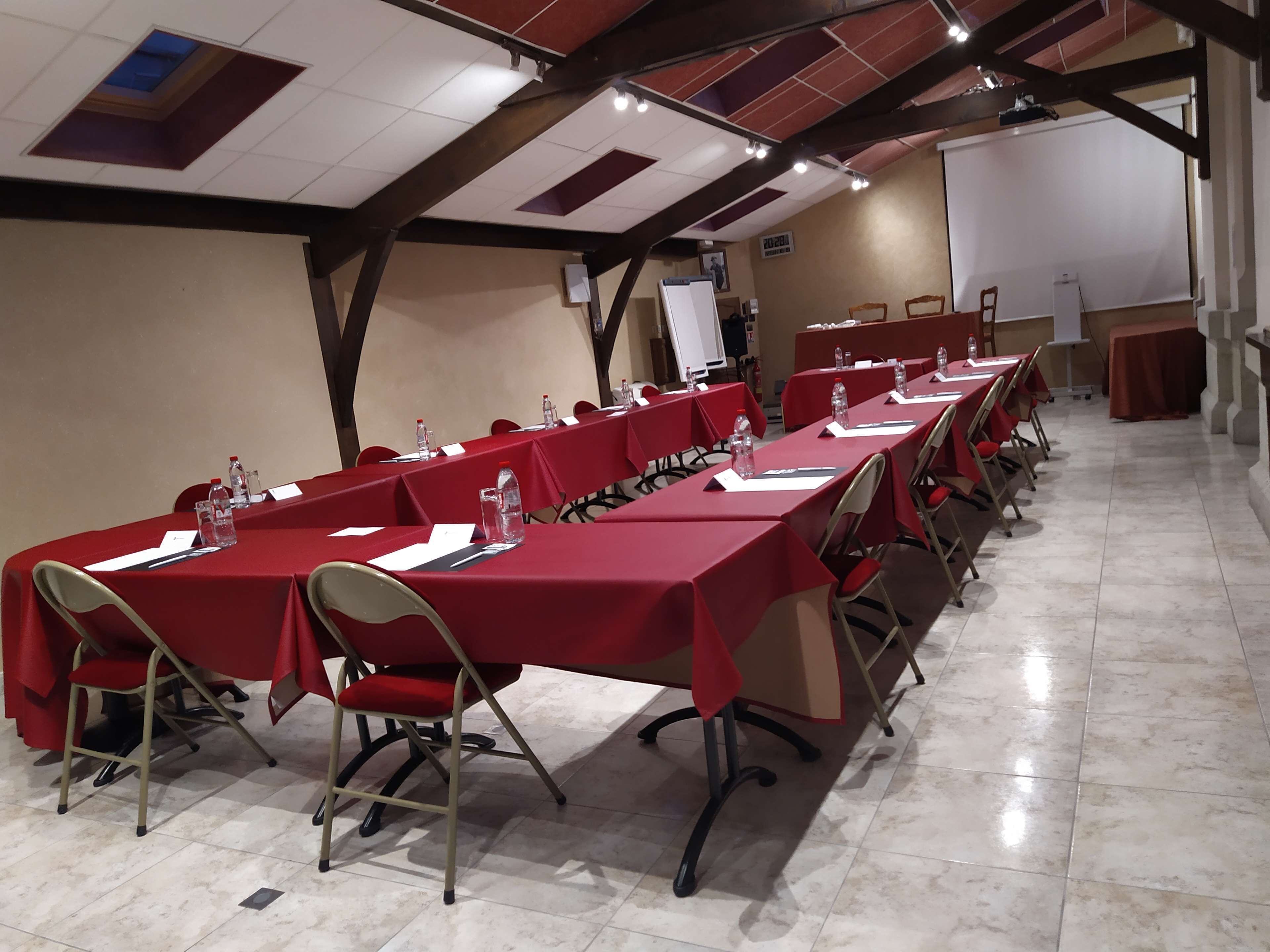 A conference room with long tables, chairs, and a whiteboard.