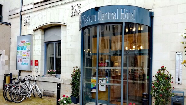 The exterior of the Western Central Hotel with a glass entrance, potted plants, and bicycles parked outside. - Best Western Central Hotel (Tours)