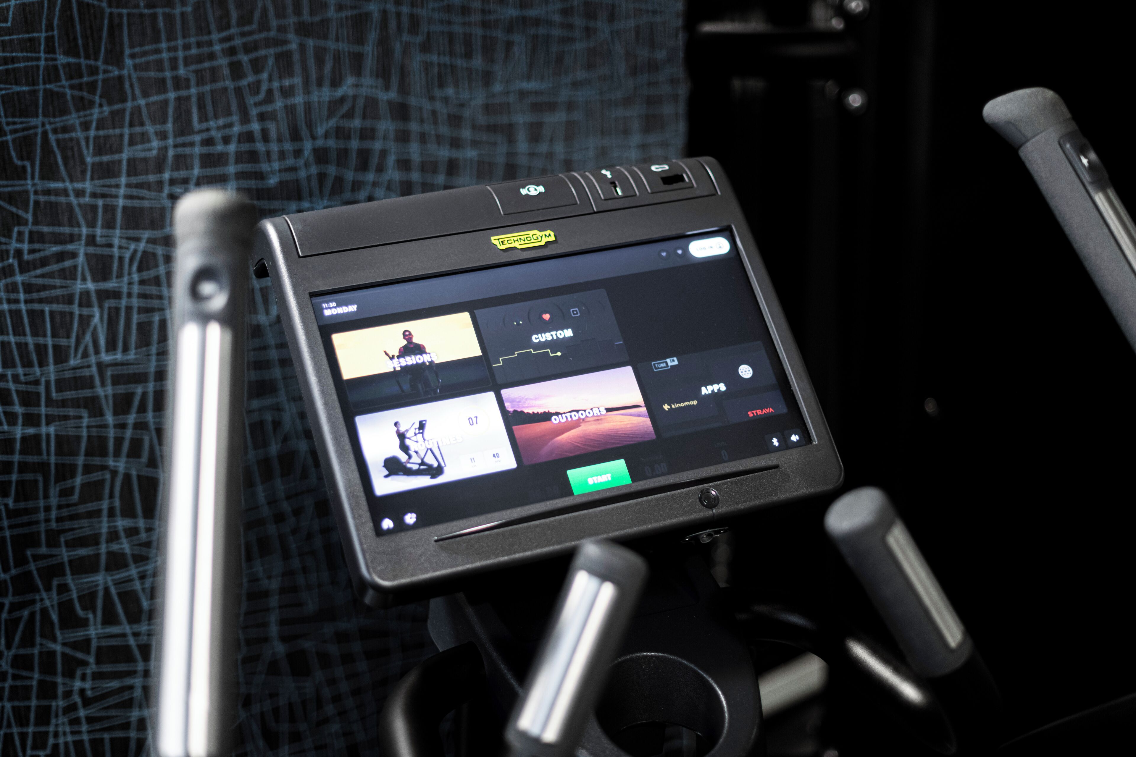 A tablet on a stand displaying a music app with various categories.