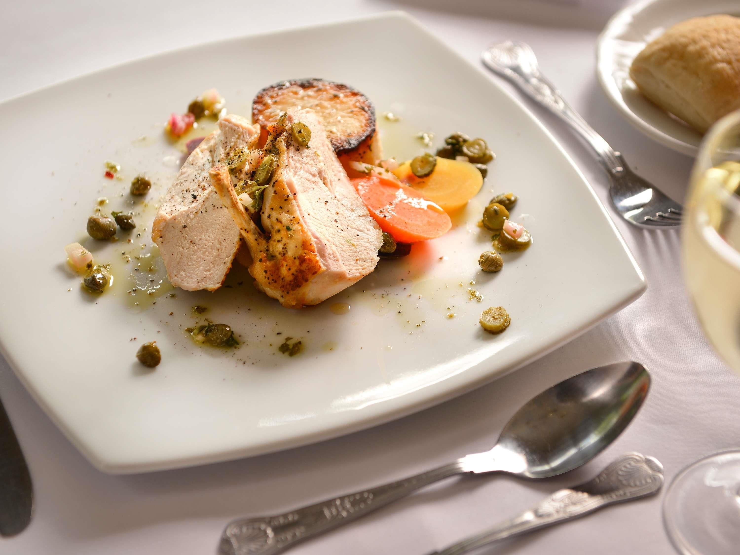 A plate of food with a white plate, a fork, and a spoon.