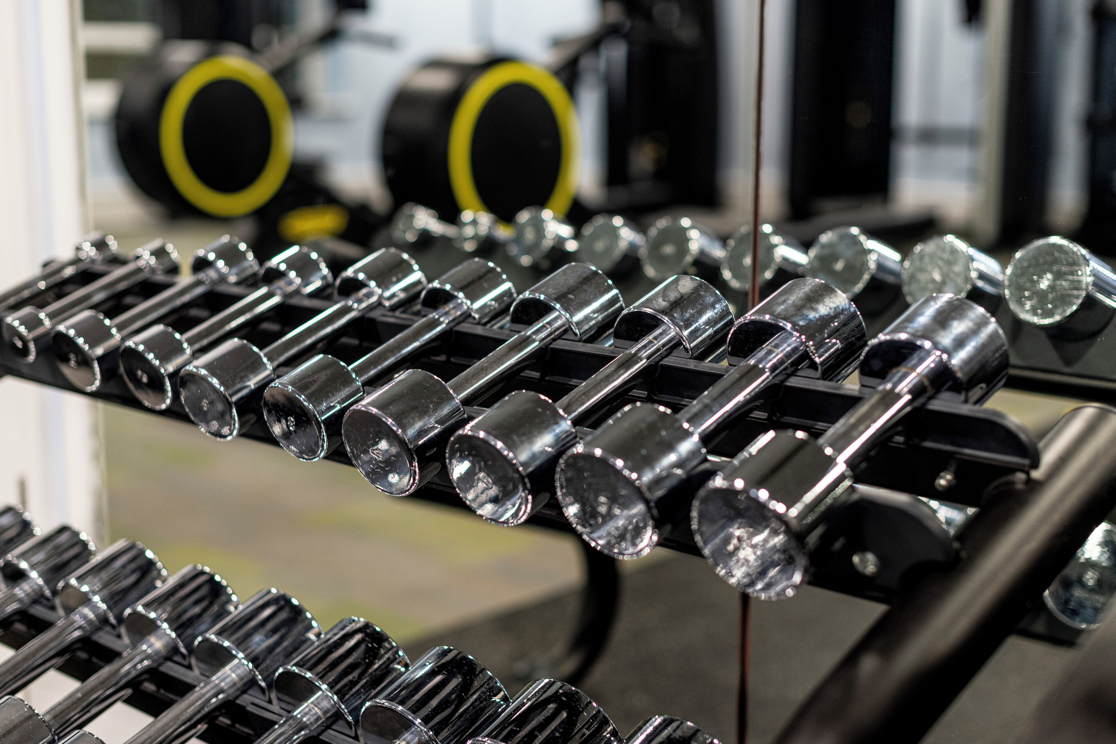 A rack of dumbbells in a gym setting.