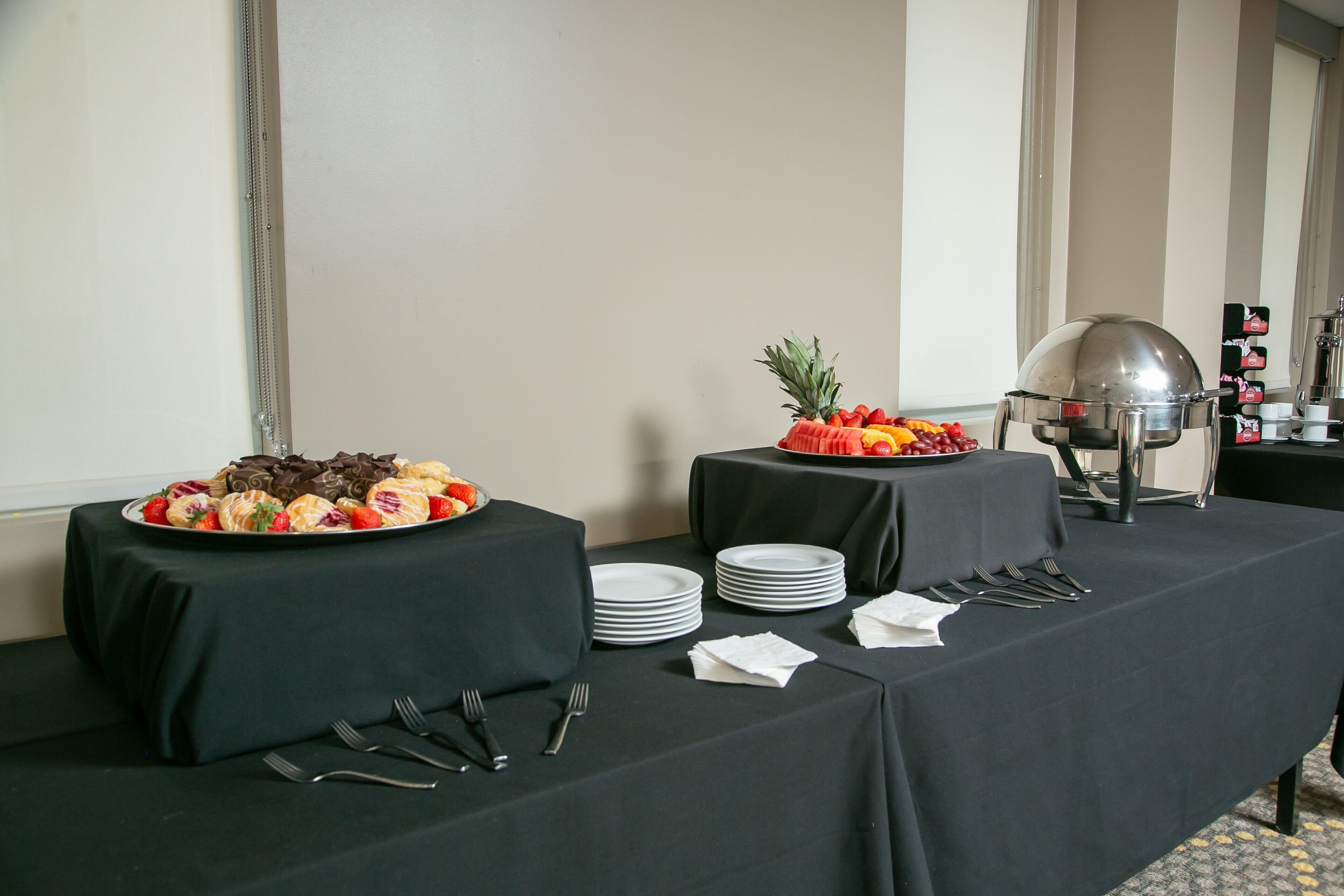 A buffet table with various food items and a coffee station.