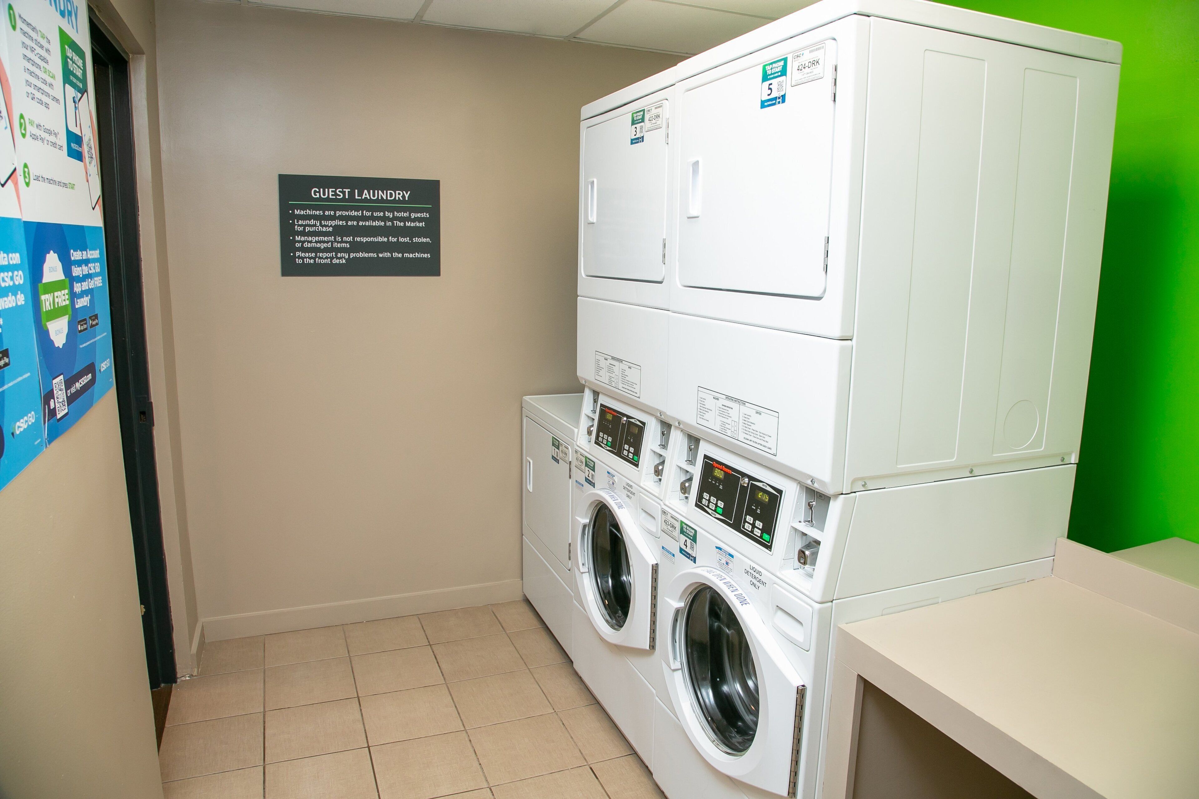 A laundry area with a sign indicating guest laundry services, including instructions and a note about machine availability.