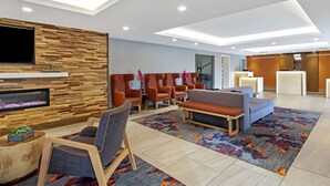Un hall d’entrée moderne avec un mur en bois, un espace salon et un téléviseur à écran plat.