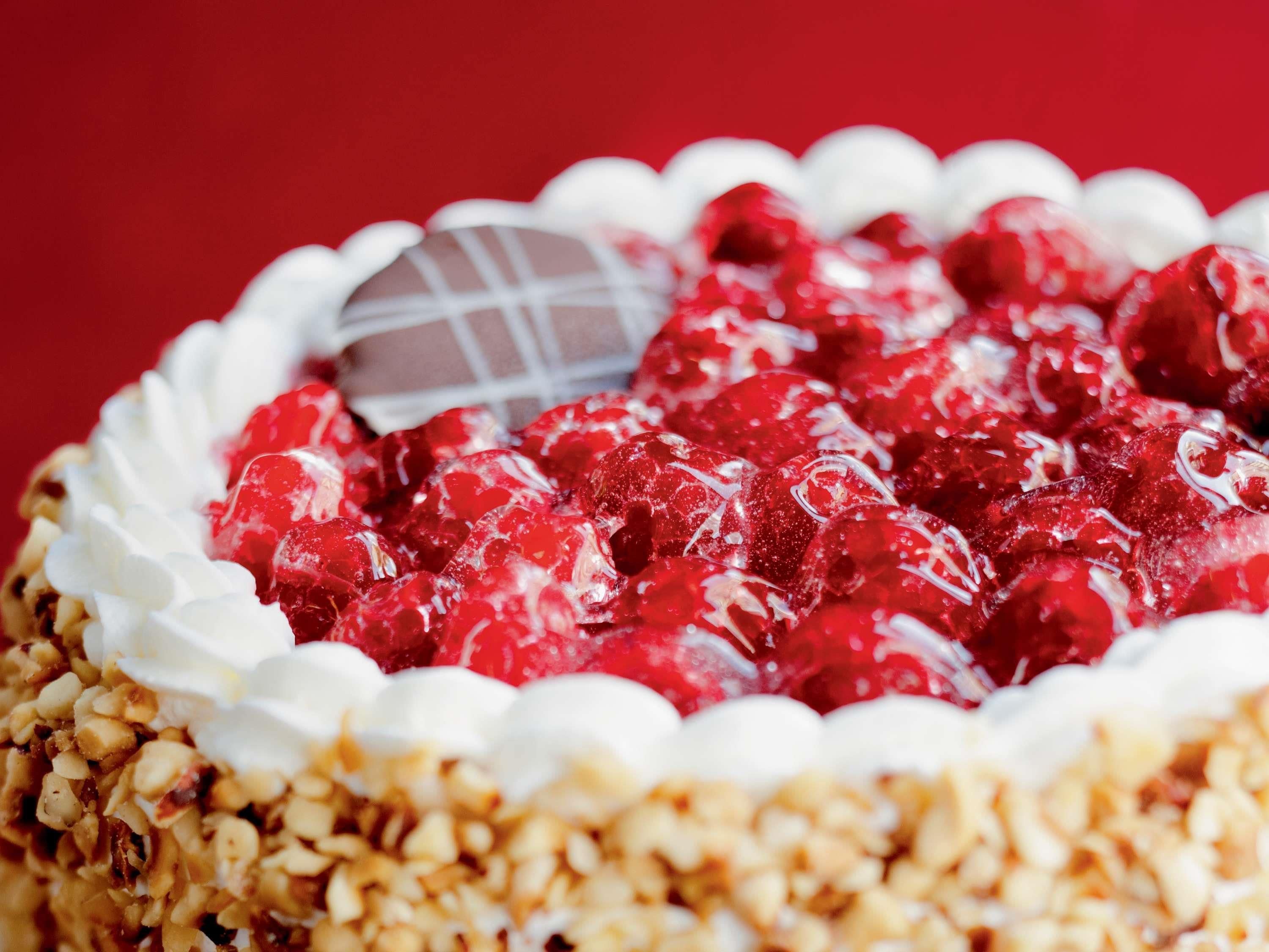 A dessert with a white topping and red fruit.