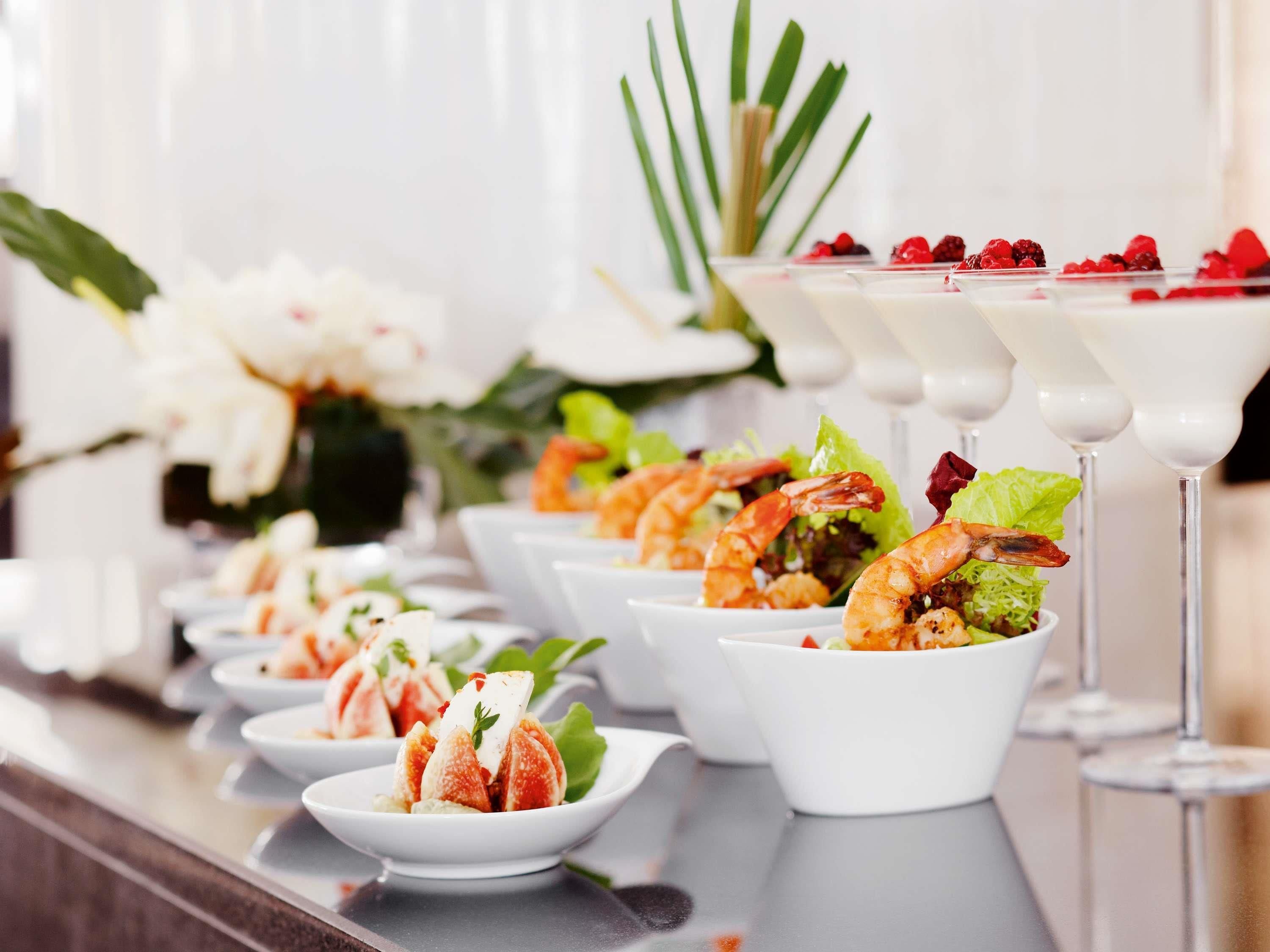 Un bufé con camarones, ensalada y copas de martini.