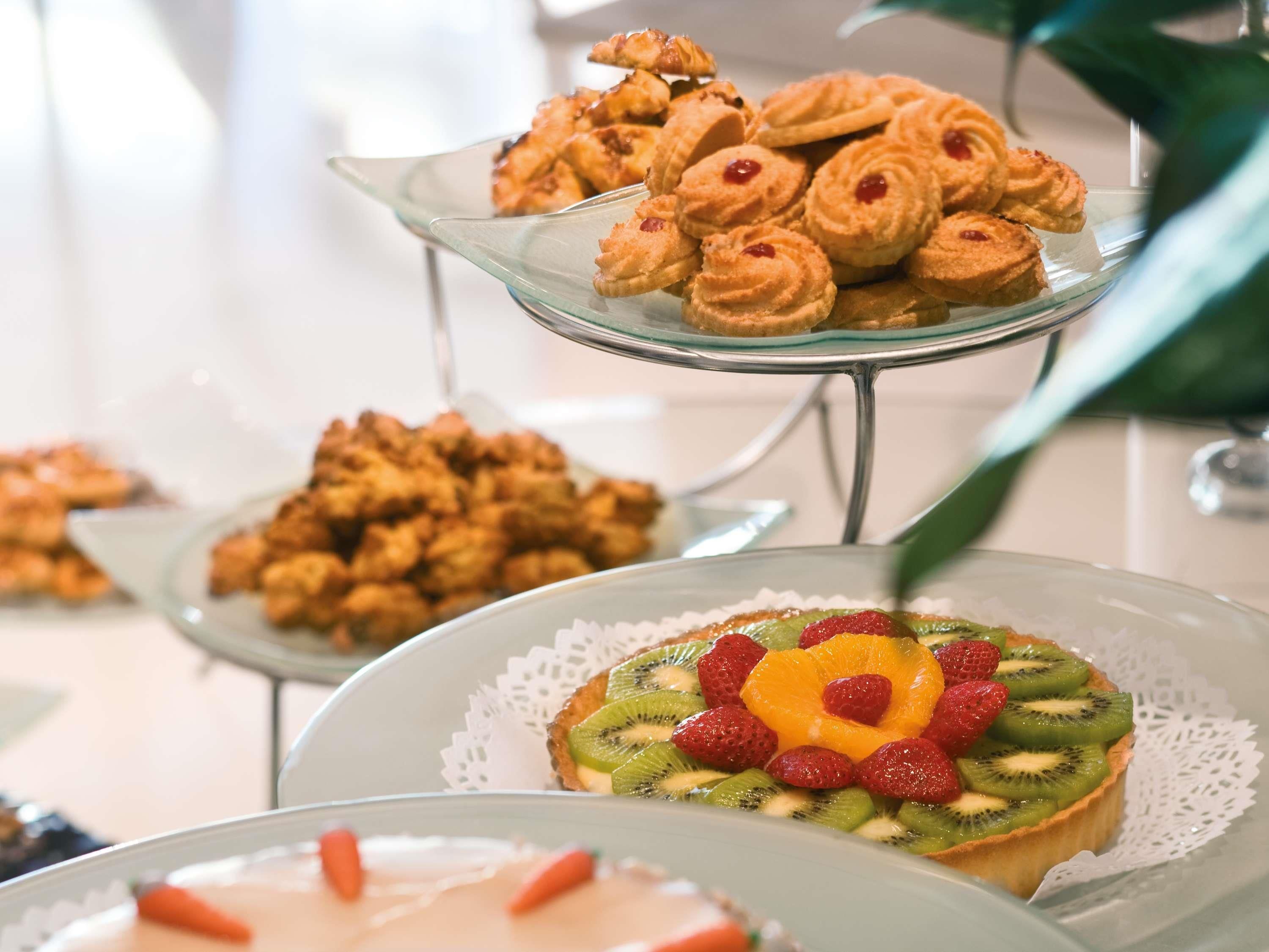 Una presentación de postres con diversos pasteles y una tarta de frutas.