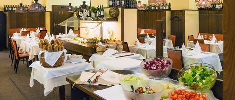 A buffet setup with various food items and a wine selection.