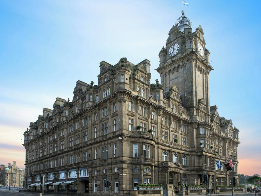 A historic building with a prominent clock tower, large windows, and a formal entrance.