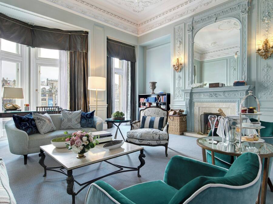 Un salon spacieux avec un canapé, des fauteuils, une table basse et une cheminée.