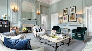 A spacious living room with a fireplace, elegant furniture, and decorative wall art.