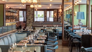 A restaurant with a bar area, seating arrangements, and a view of the outdoors.