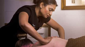 Guests can enjoy a soothing massage in a serene space with a massage table and a therapist's skilled touch.