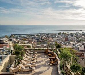 A rooftop terrace with sun loungers and a view of the sea and cityscape. - Radisson Hotel President Old Town Istanbul (Istanbul)