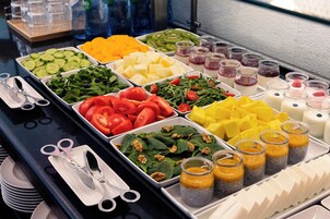 A buffet with various food items including fruits, vegetables, and desserts.