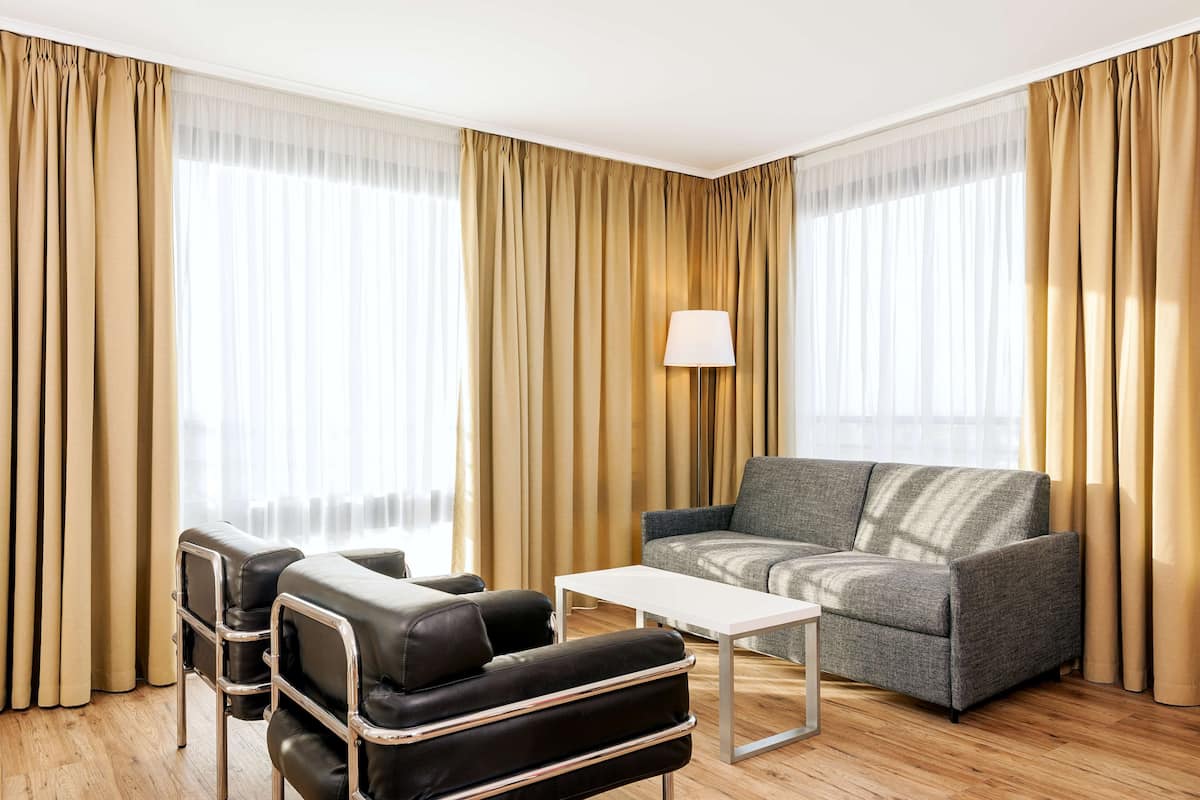 Una sala moderna con un sofá, sillones y una mesa de centro.