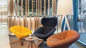A modern interior with three chairs, a table, and a lamp. - NH Dortmund (Dortmund)