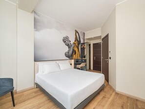 A modern bedroom with a bed, a desk, and a wardrobe. - B&B Hotel Como City Center (Como)