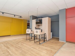 A modern office space with two desks, a flat-screen TV, and pendant lighting. - B&B Hotel Como City Center (Como)