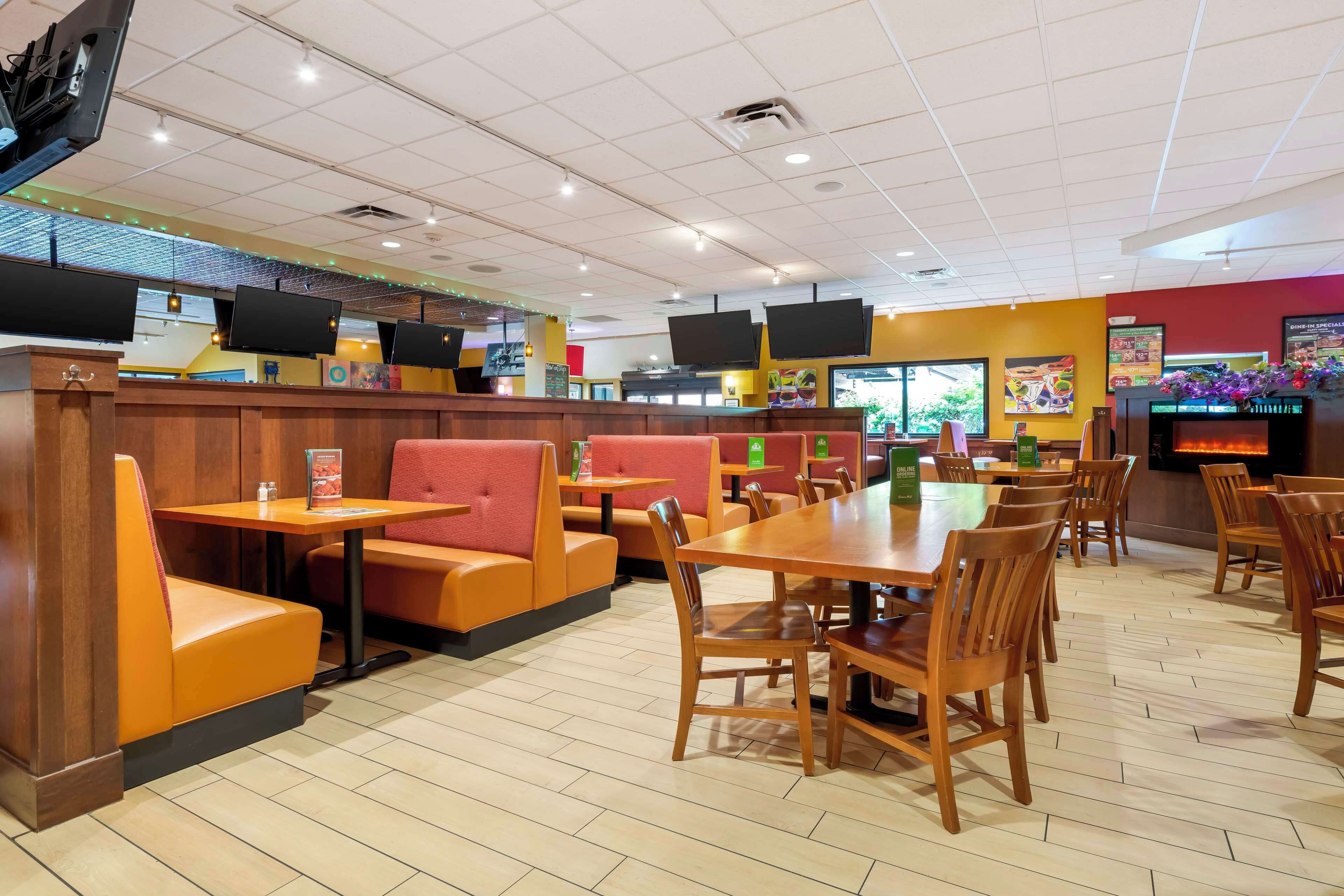 A restaurant with booths, tables, and a counter.