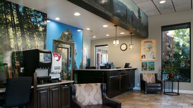 A reception area with a desk, chairs, a clock, and a map on the wall.
