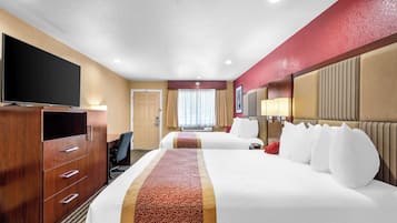 Une chambre d’hôtel avec deux lits, une télévision, un bureau et un grand miroir.