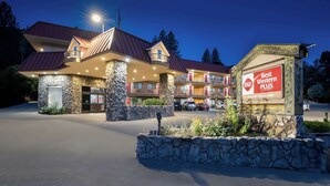 A multi-story hotel with a stone facade, multiple balconies, and a sign indicating it is the Best Western Plus Yosemite Way Station.
