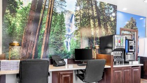 A home office with a large desk, two office chairs, a computer, a printer, and a coffee machine.