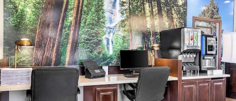A home office with a large desk, two office chairs, a computer, a printer, and a coffee machine.