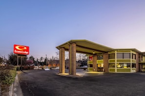 Un Econo Lodge con una estación de servicio adosada, que cuenta con fachada de ladrillo y zona de estacionamiento techada.