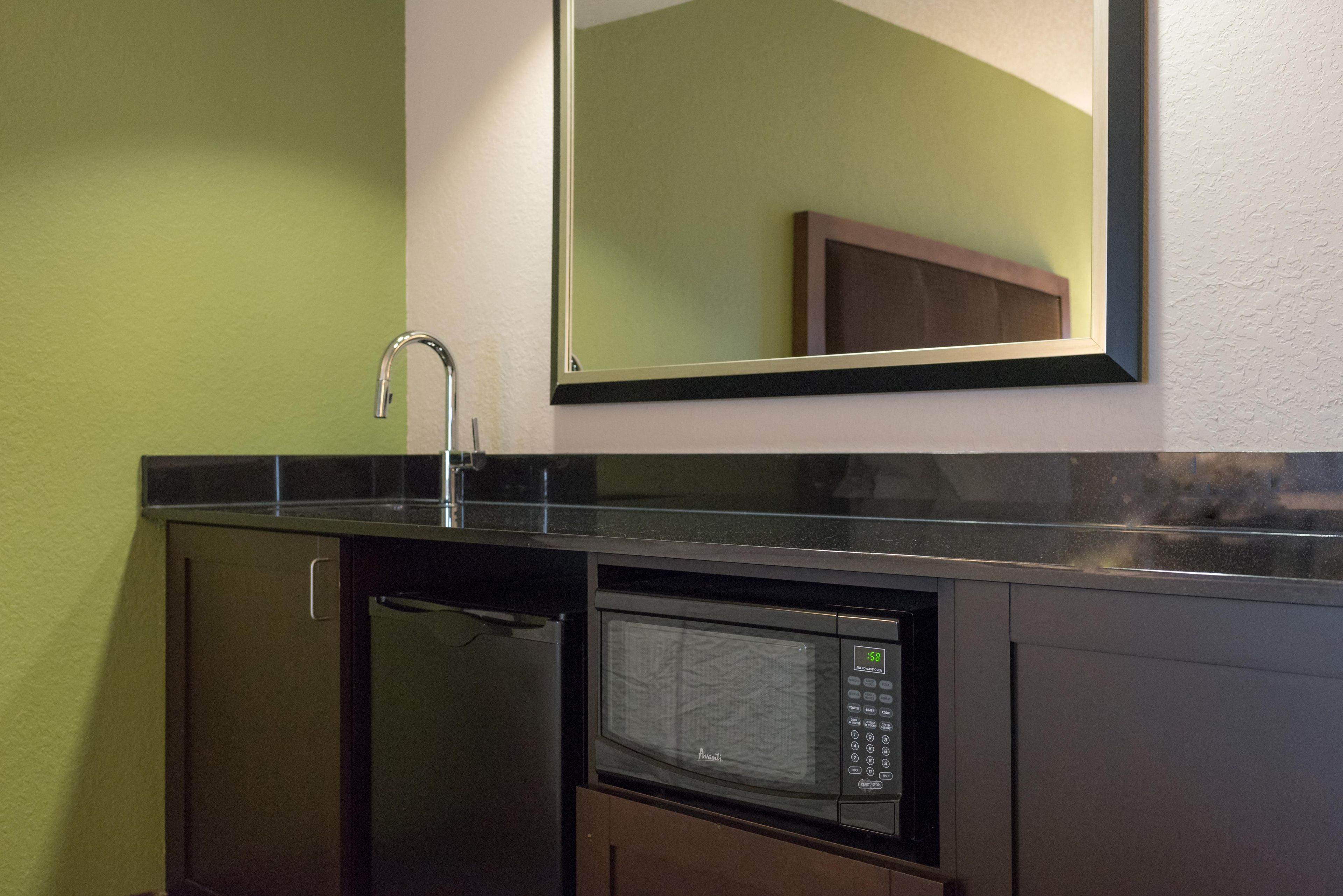 A kitchen with a microwave, a sink, and a cabinet.