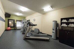 A gym with treadmills, a stationary bike, and a red exercise ball.