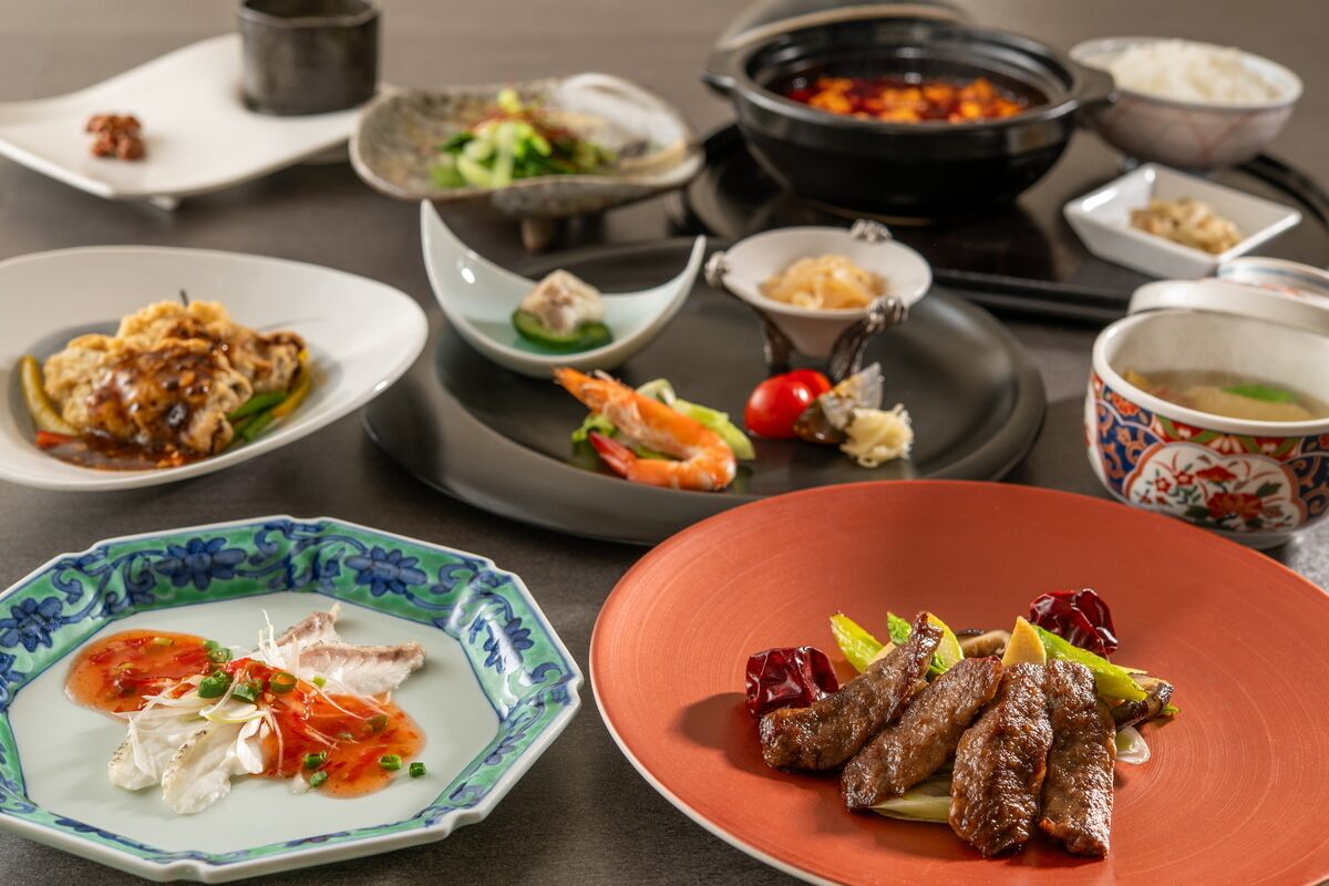 A variety of dishes on a table, including seafood, vegetables, and meat.