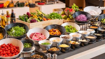Una mesa de buffet con diversos alimentos y salsas.
