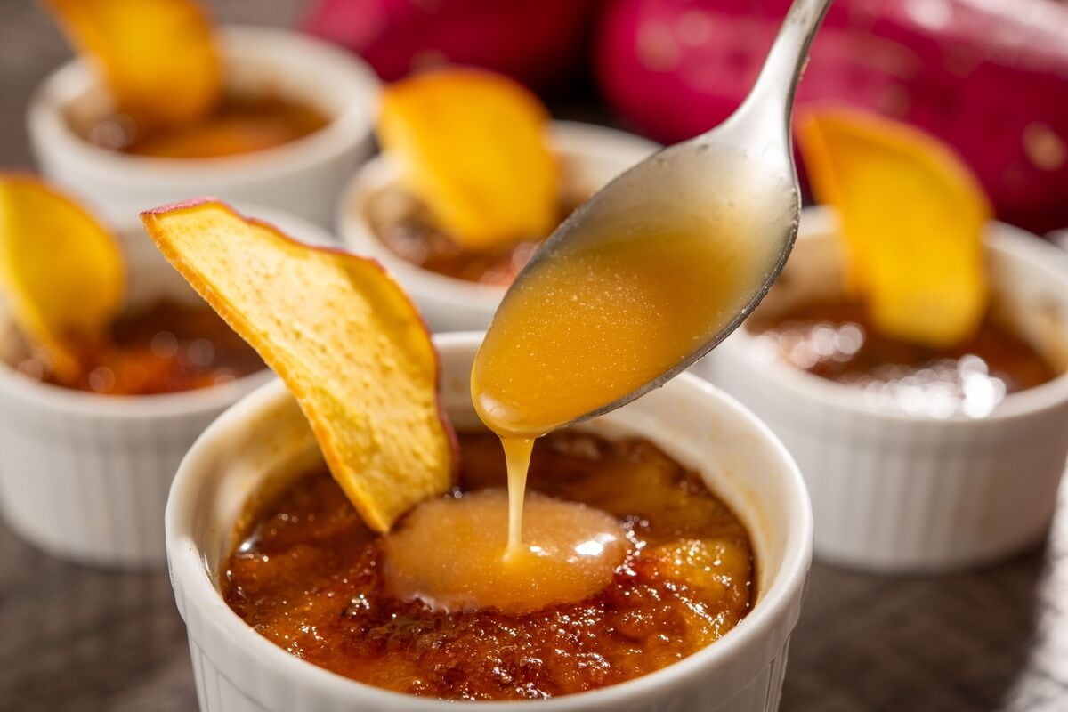 A dessert with a golden sauce being served into a white bowl.